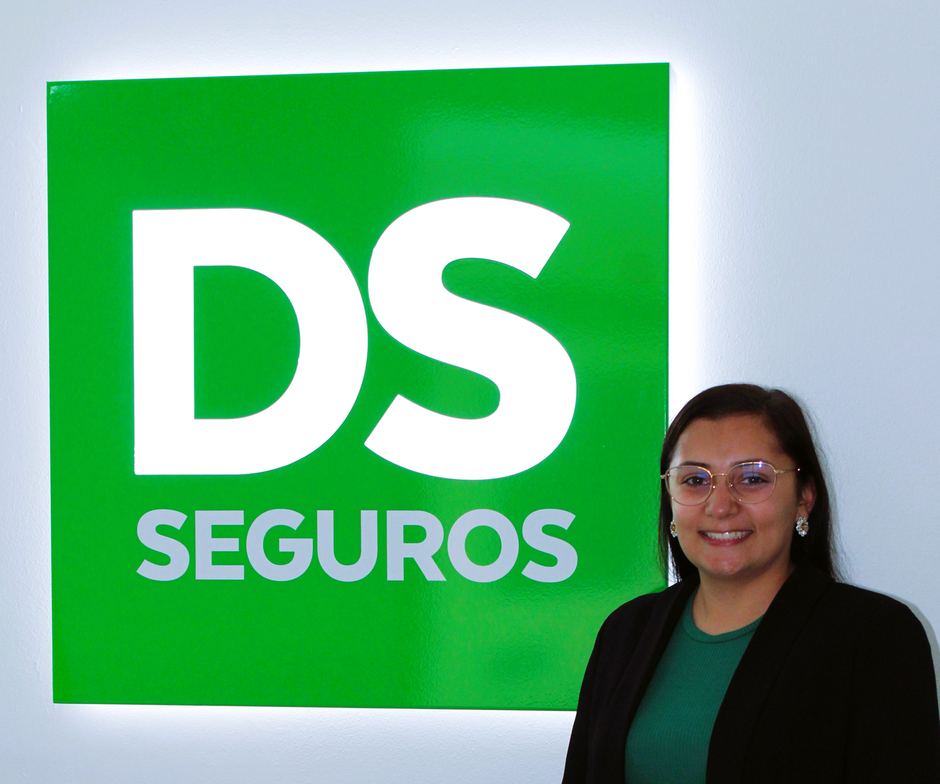 Retrato de Inês Carvalho à frente da parede verde com o logótipo DS Seguros.
